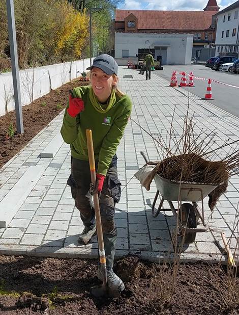 Ländschaftsgärtnerin Janine arbeitet mit einer Schaufel