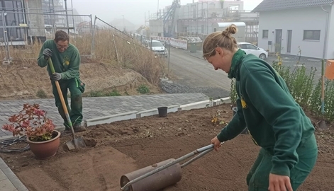 Marike arbeitet gemeinsam mit einem Kollegen auf einer Gartenbaustelle