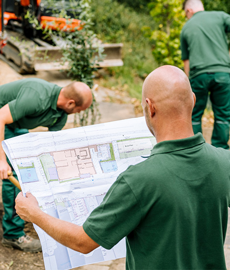 Bauleiter hält einen Bauplan in der Hand